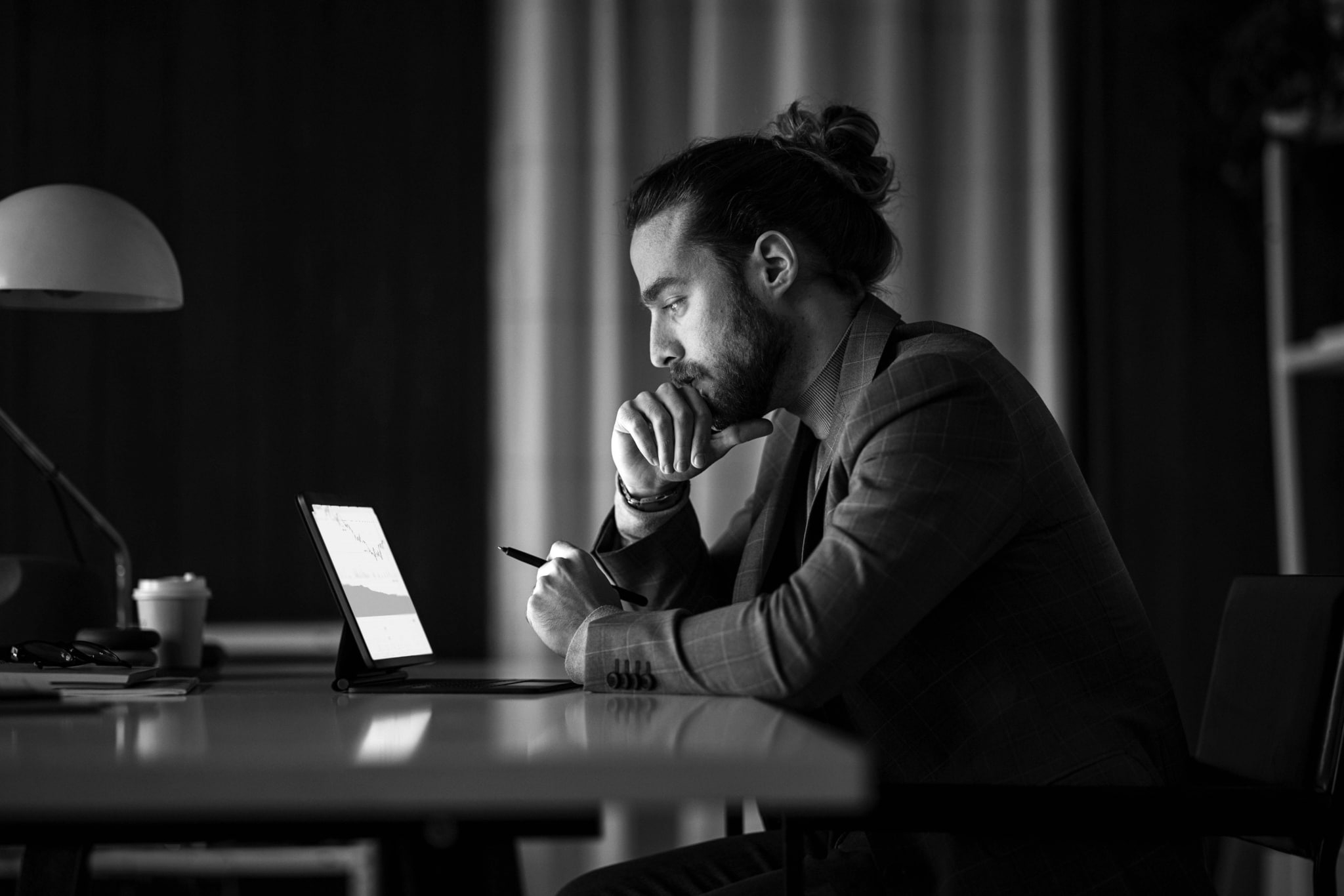 Black & white photo of man working on his laptop
