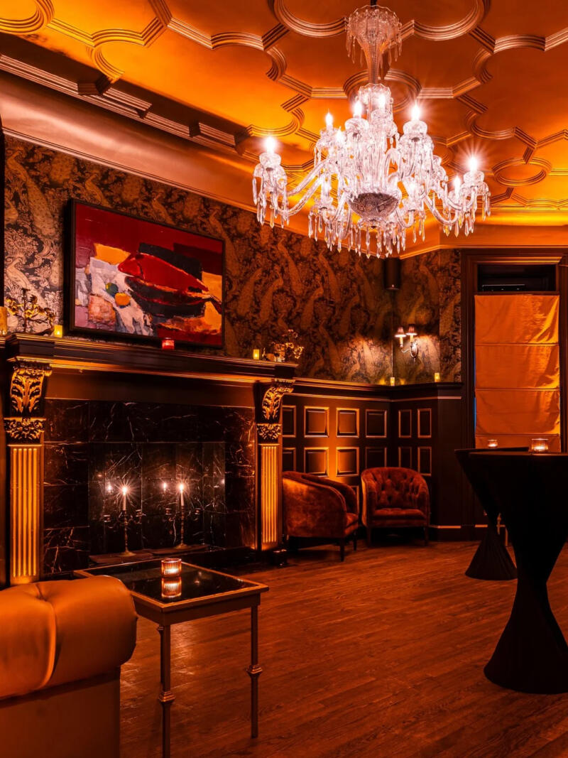 The fireplace lounge at Raines Law Room at the William, set for an evening reception